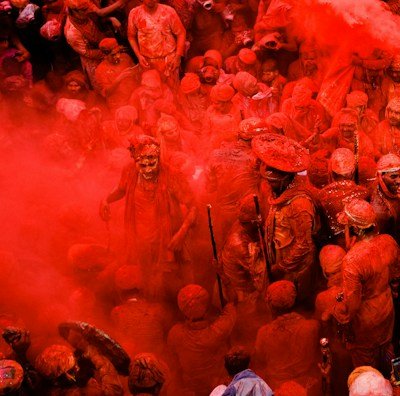 people in blue shirts with red powder on their hands
